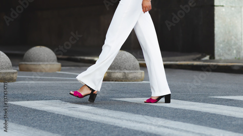 Legs of a girl in a white pants