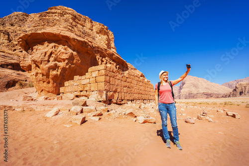 The ruins of Lawrence’s House and tourist taking selfie in Wadi Rum desert, Jordan.