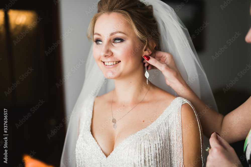 Naklejka premium Luxury bride in white dress posing while preparing for the wedding ceremony