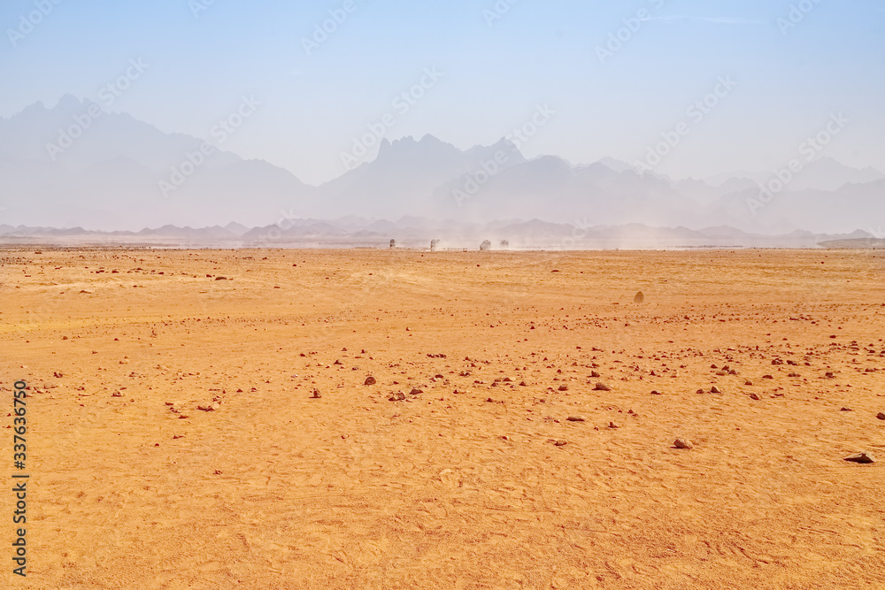 Hot desert with mirage on a background of mountains
