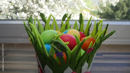 Colorful Easter eggs in a beautiful basket by the kitchen window.