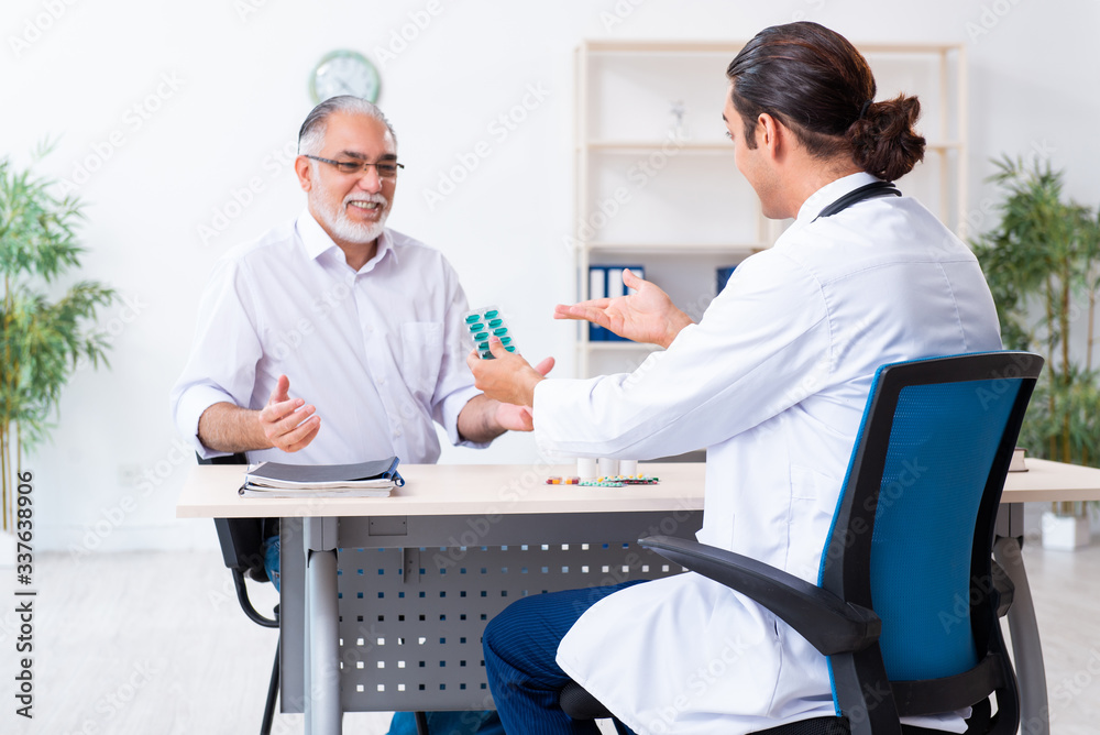 Obraz premium Old man visiting young male doctor
