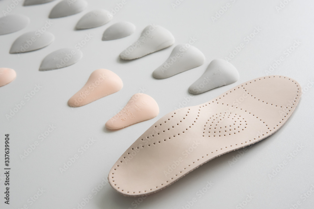 Orthopedic insole on a white background. Treatment and prevention of flat feet and foot diseases. Foot care, foot comfort. Wear comfortable shoes. Orthopedic insole on a white background. Treatment and prevention of flat feet and foot diseases. Foot care, foot comfort. Wear comfortable shoes.