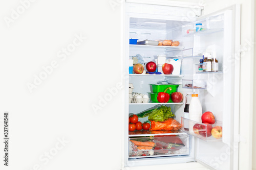 Wallpaper Mural Top freezer kitchen refrigerator with doors open and shelves full of groceries with fresh and frozen food and cold bottles Torontodigital.ca