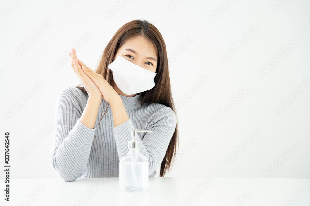Woman wearing face mask protective for spreading of disease virus SARS-CoV-2 and hand wash cleaning by alcohol gel with copy space for protection virus, Covid-19 Coronavirus concept Woman wearing face mask protective for spreading of disease virus SARS-CoV-2 and hand wash cleaning by alcohol gel with copy space for protection virus, Covid-19 Coronavirus concept