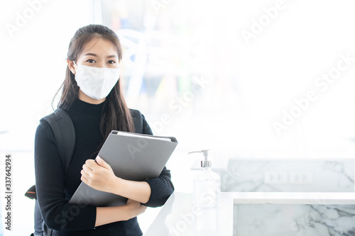 Portrait Asian young woman masked and looking to camera with copy space, anti sickness from coronavirus or covid-19 spread protection concept photo