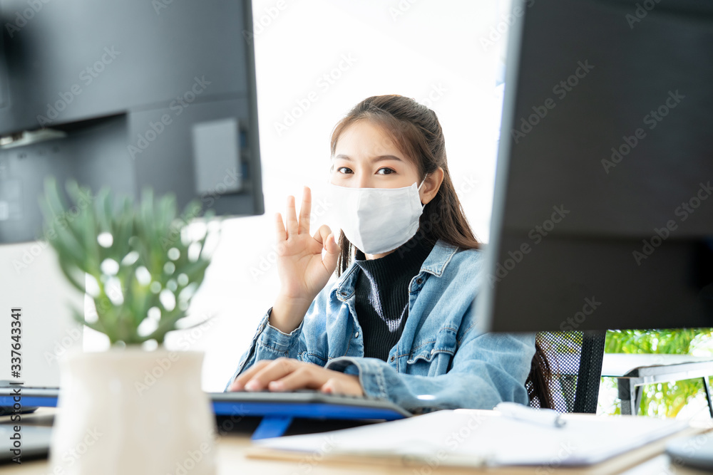 Woman wearing face mask protective for spreading of disease virus SARS-CoV-2 and hand wash cleaning by alcohol gel in office working for protection bacteria and virus, Covid-19 Coronavirus concept