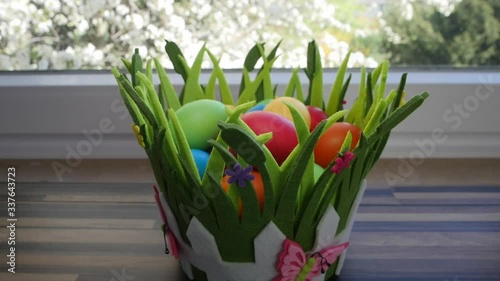 Colorful Easter eggs in a beautiful basket by the kitchen window.