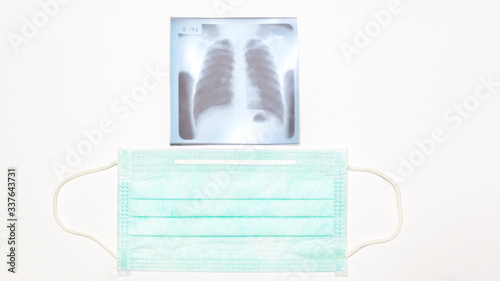 Respiratory surgical mask and lung x-ray film on white background