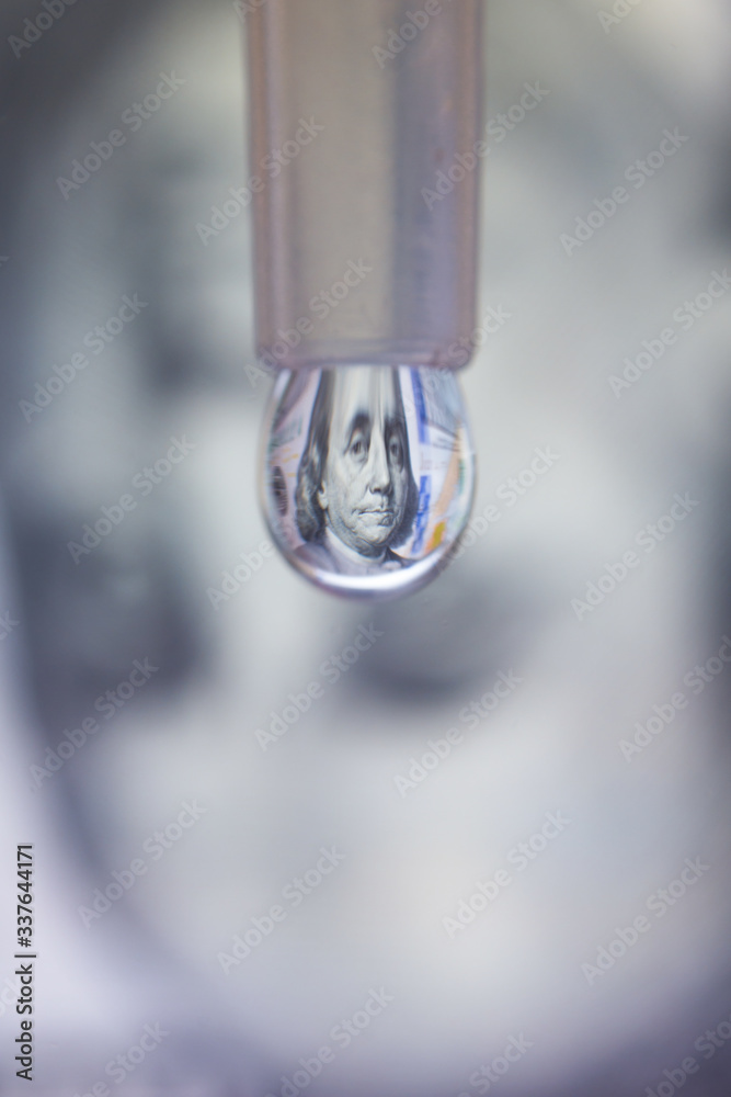 100 dollar bill reflects in a droplet. Money making by drops concept. Vertical 100 dollar bill reflects in a droplet. Money making by drops concept. Vertical