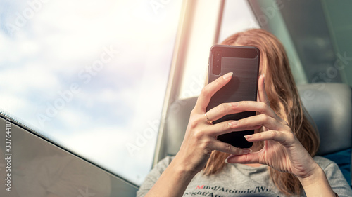 Photography Woman looking at smartphone while traveling.