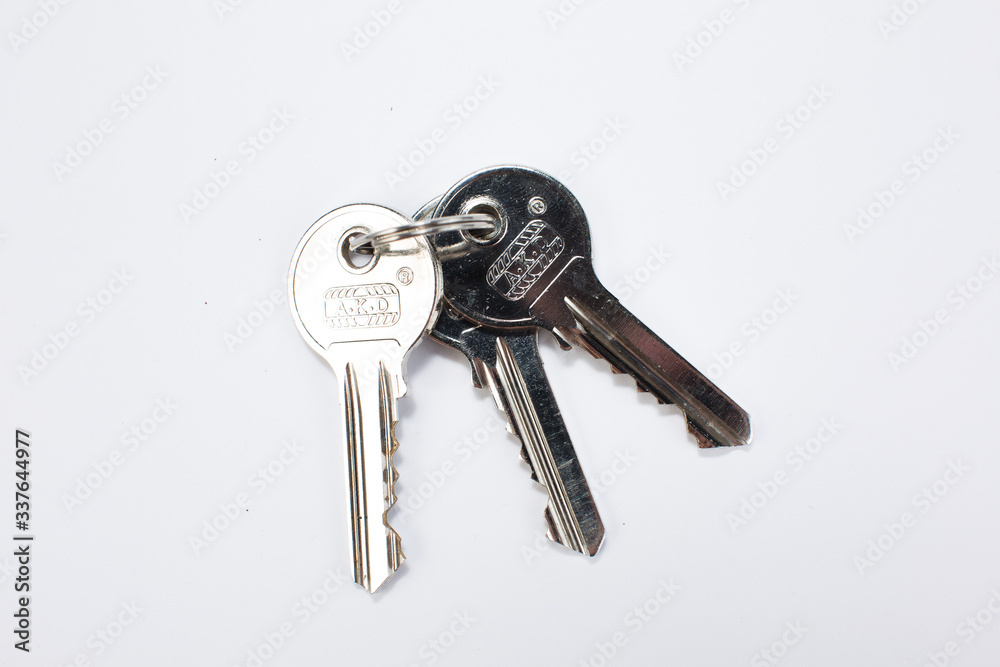 Many brass and chrome old keys on white table. Security and encryption, concept image. Many brass and chrome old keys on white table. Security and encryption, concept image.
