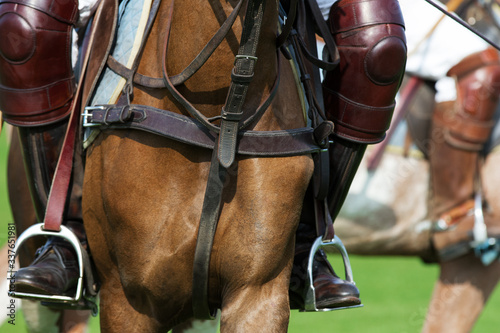 Horse polo player with riding boots in stirrups close up: protective equipment