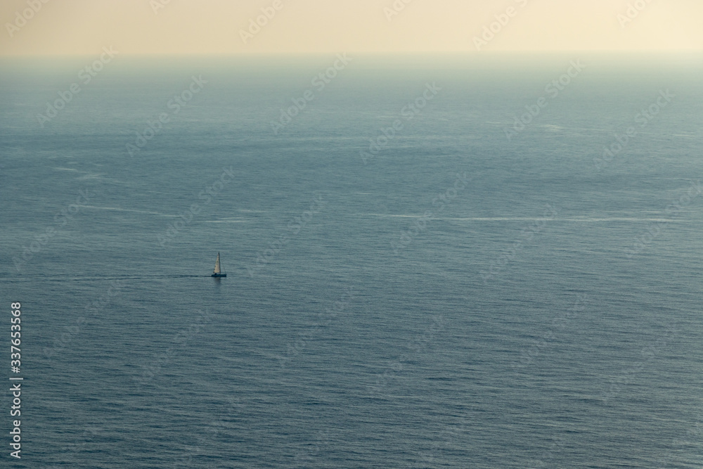 aerial view of a single Sailing boat in open blue sea from the viewpoint cap andritxol, mallorca, Spain