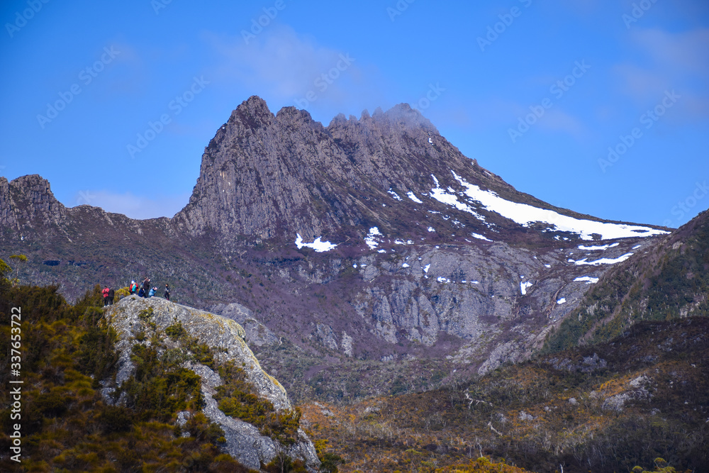 The cliff with people with snow mountain background in Tasmania, Australia