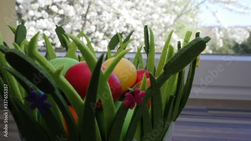 Colorful Easter eggs in a beautiful basket by the kitchen window.