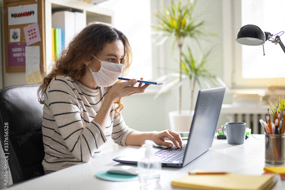 Young business woman working from home wearing protective mask Young business woman working from home wearing protective mask