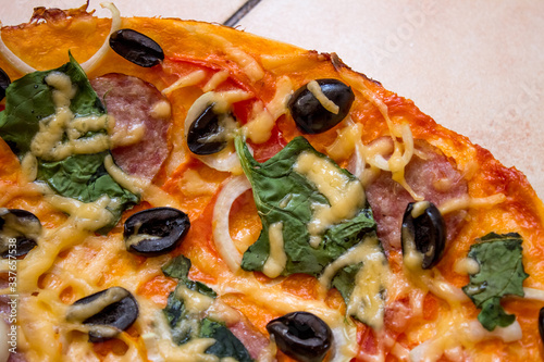 Italian pizza with salami vegetables and spinach