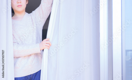 Lady is opening curtain and window