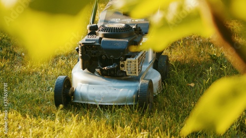Lawn mower on green lawn, shallow depth of field