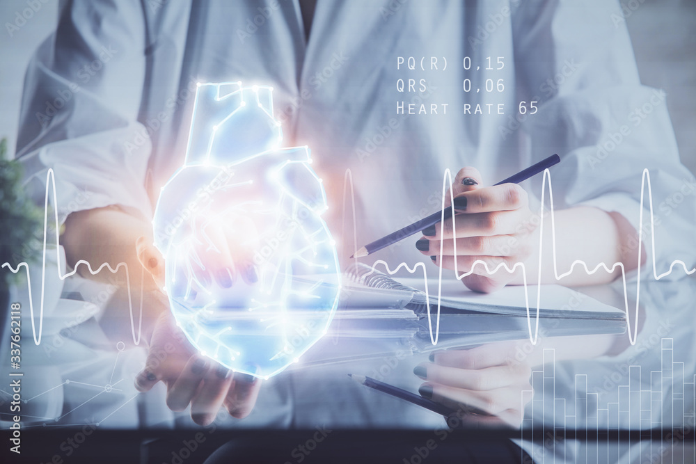 Heart hologram over woman's hands writing background. Concept of Medical study. Multi exposure Heart hologram over woman's hands writing background. Concept of Medical study. Multi exposure