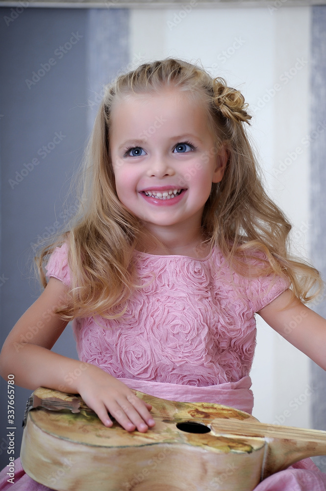 Cute little blonde girl in a pink dress with curls with a vintage ...