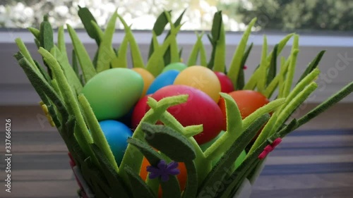 Colorful Easter eggs in a beautiful basket by the kitchen window.