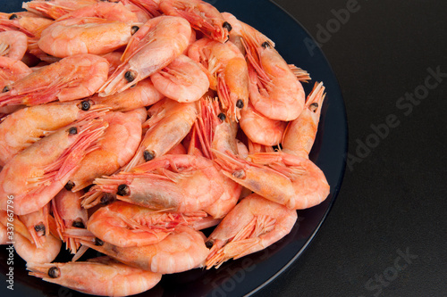 Boiled shrimp on a plate on a black background