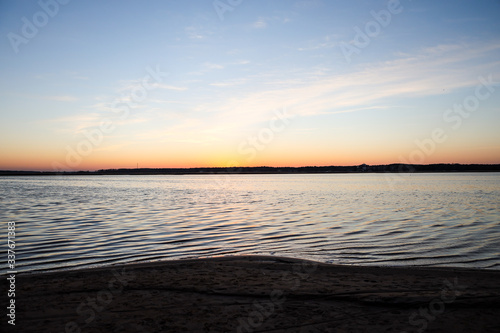 Beautiful landscape view with river slowly flowing with small waves during the sunset.