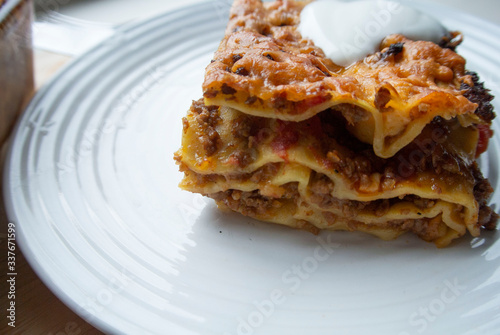 Juicy meat lasagna, cassic dish of Italian cuisine with dough, meat and sauce with creamy soft mozzarella cheese.