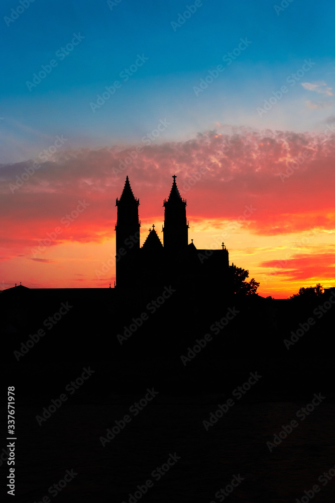 Silhouette of Cathedral of Magdeburg during bloody red sunset at Spring in Magdeburg, Germany, postcard