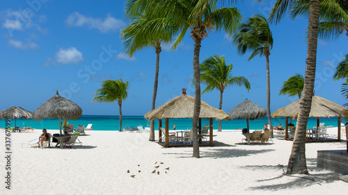 White sand, palm trees and small huts at Bucuti (Eagle) Beach, Aruba.