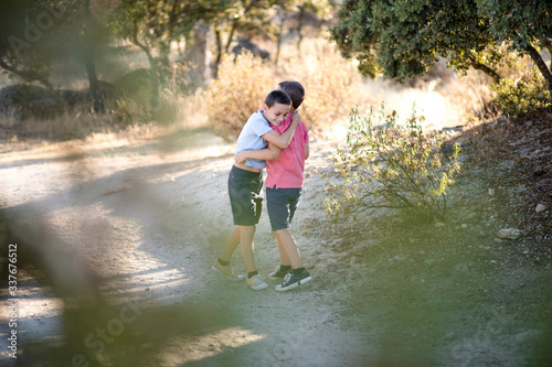 Fototapeta Naklejka Na Ścianę i Meble -  Two boys hugging and playing in nature. Siblings love.
