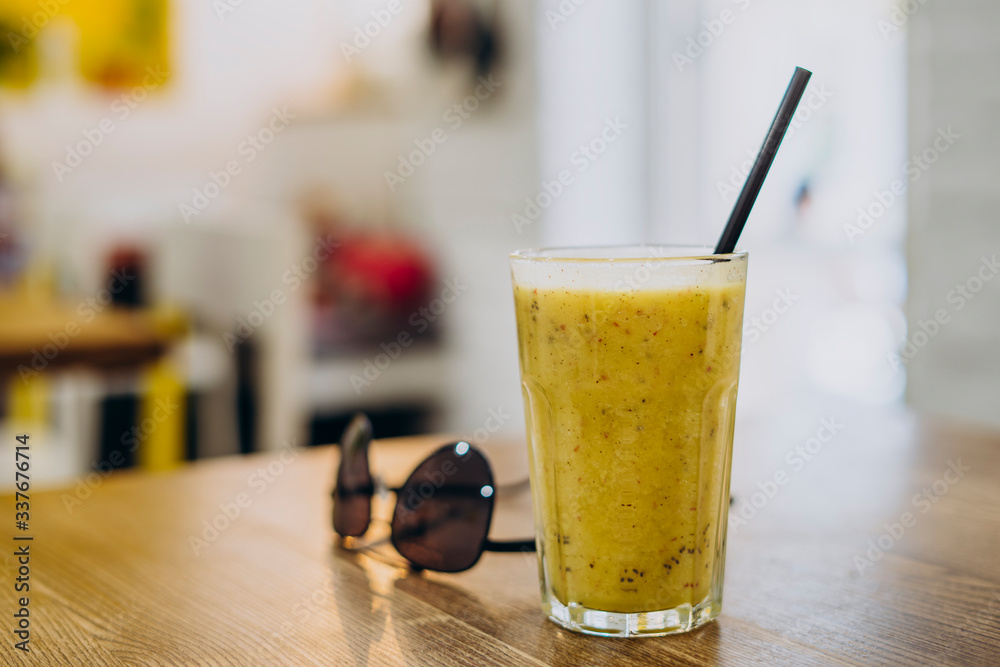 Glass of yellow smoothie on the table. Glass of yellow smoothie on the table.