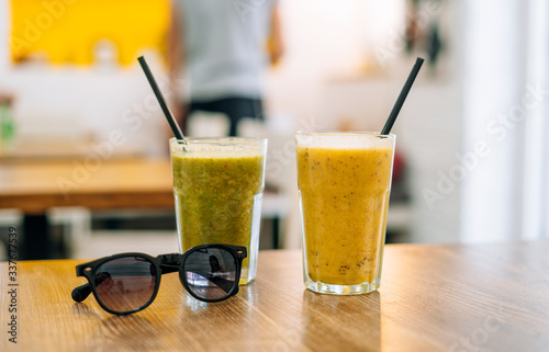 Two glasses of appetizing smoothie in summer cafe. Vegetable smoothie