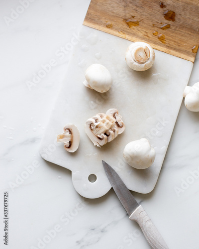 Fresh sliced champignon mushrooms on cutting board.
