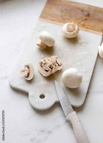 Fresh sliced champignon mushrooms on cutting board.