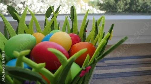 Colorful Easter eggs in a beautiful basket by the kitchen window.