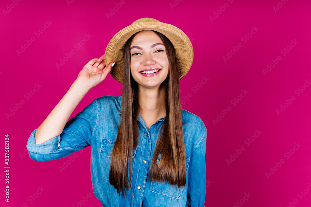 joyful girl in a hat and denim shirt joyfully smiles at the camera on a pink background joyful girl in a hat and denim shirt joyfully smiles at the camera on a pink background