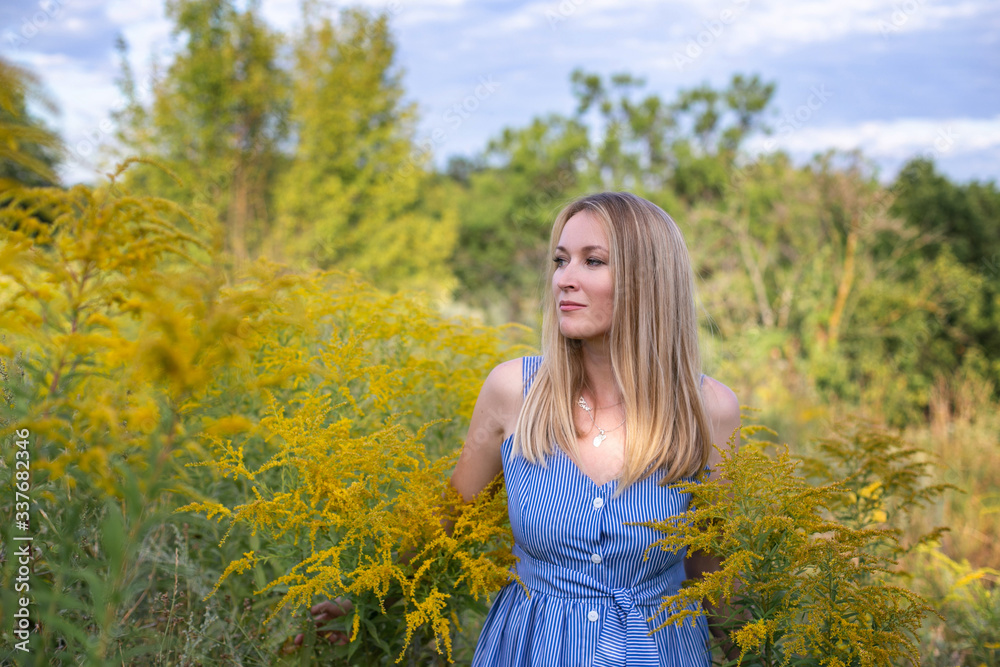 horizontal closeup portrait of a charming blonde on a background of a blooming field outside the city horizontal closeup portrait of a charming blonde on a background of a blooming field outside the city