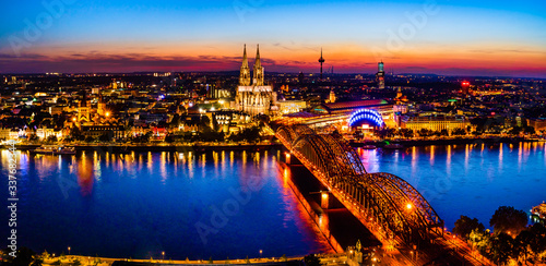 Cologne, Germany: Beautiful panoramic aerial night landscape of the gothic catholic Cologne cathedral, Hohenzollern Bridge and the River Rhine at sunset, golden hour and blue hour.