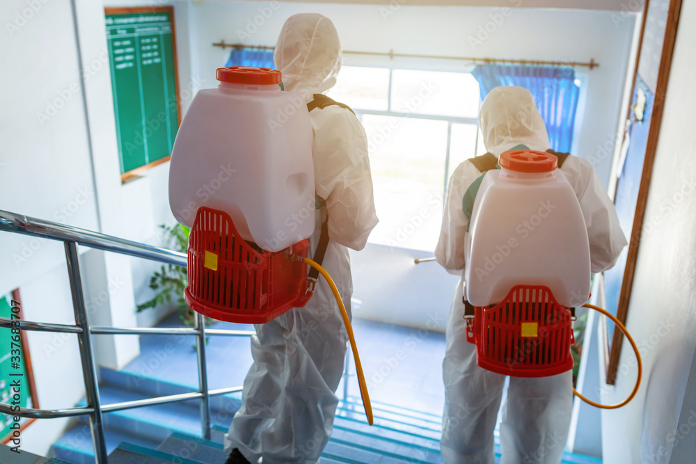Φωτογραφία Disinfection, People in virus protective PPE suits and mask disinfecting buildings of coronavirus with the sprayer, State of emergency over coronavirus