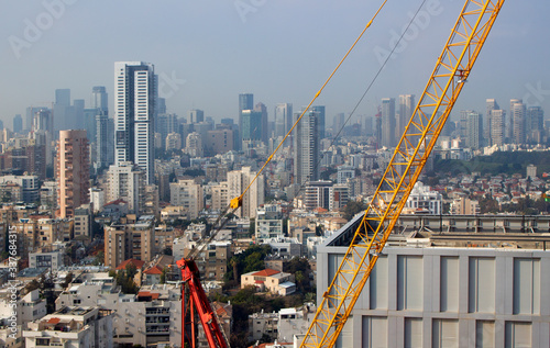 Modern city. Office building top view. Crane and building construction site against the blue sky. Isreal, Ramat Gan, Bnei Brak, Tel Aviv, Tel Aviv-Yafo photo