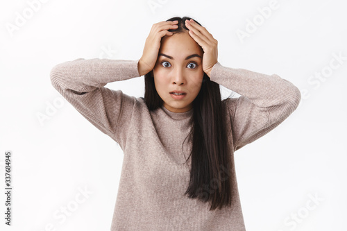 Annoyed and pressured, distressed fed up asian girlfriend tired constantly saying same things, grab head bothered, stare camera intense, losing temper feeling fatigue and irritation, standing angry