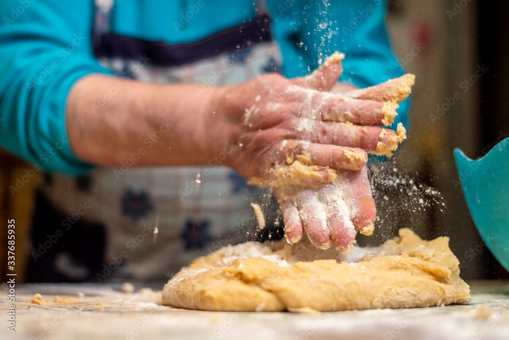 Woman's hands preparing the dough for the fried donuts of Easter