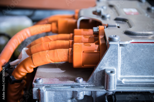 Huge orange power supply cables connected to electric car inverter.
