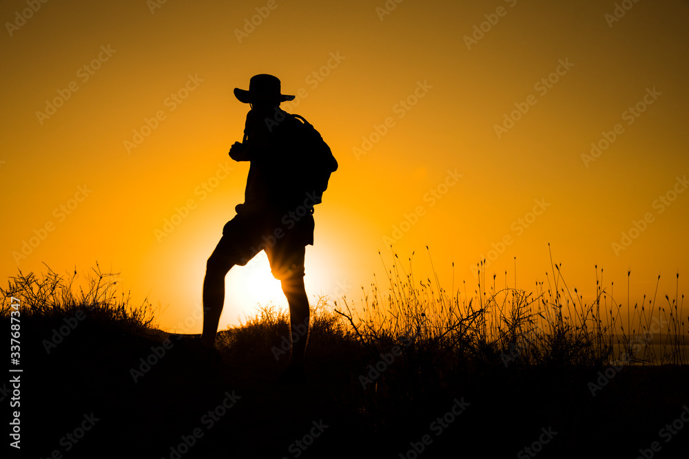 Silhouette of a womanwith a backpack in thesunset. Silhouette of a womanwith a backpack in thesunset.