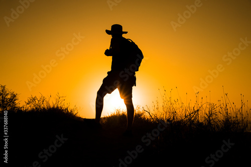 Silhouette of a womanwith a backpack in thesunset.