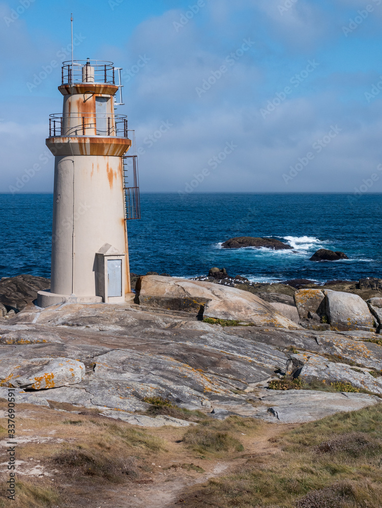 Lighthouse at Punta da Barca, next to the Sanctuary of Virxe da Barca in Muxia, Galicia, Spain