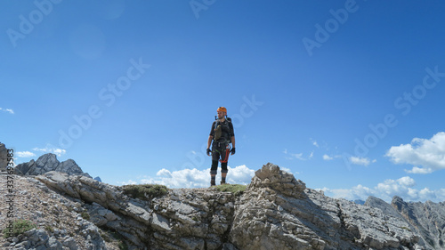 Tourist with equipment on a mountain trail in the Alps